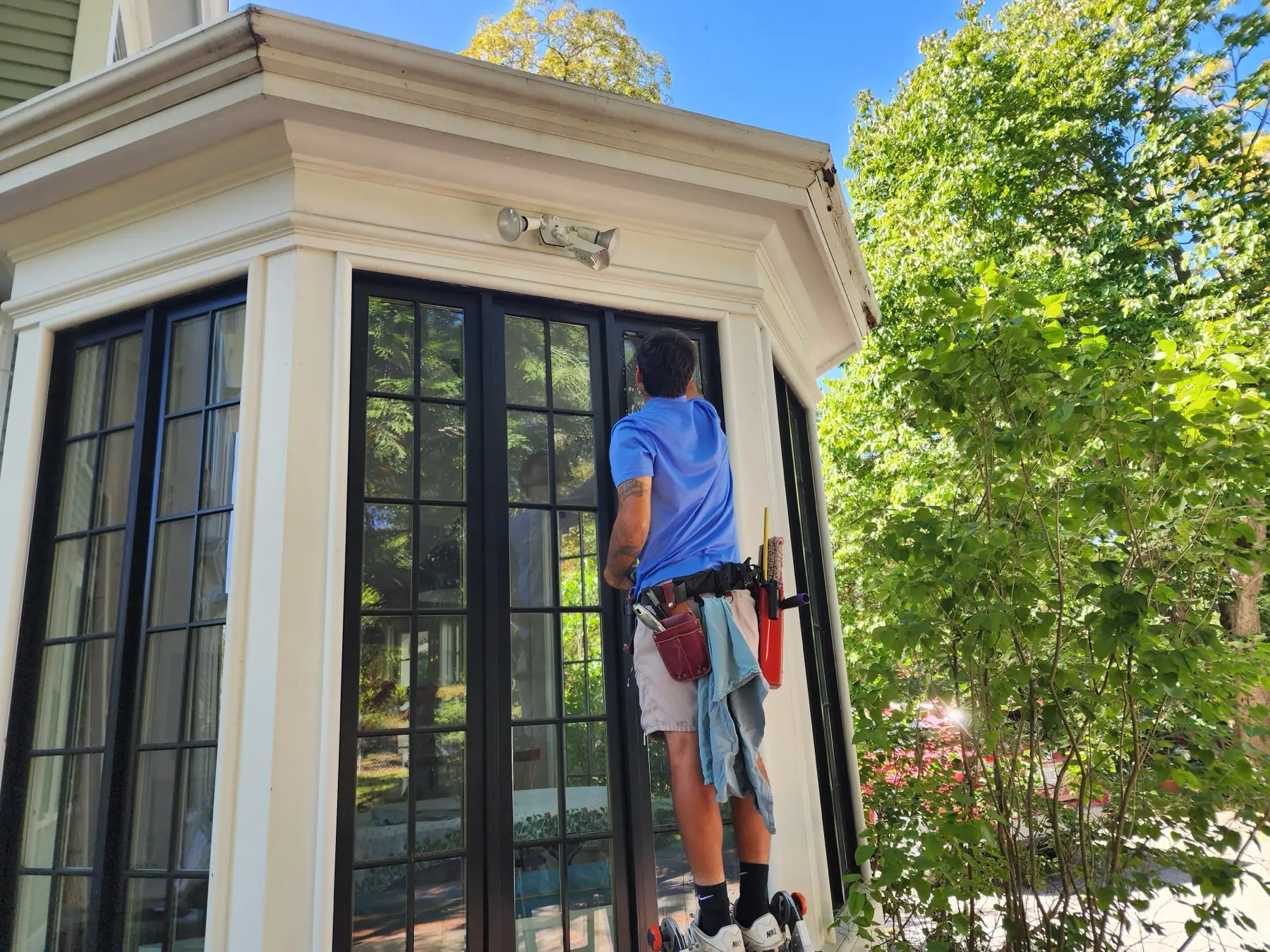 See Through technician cleaning a sun-porch window on a Midcoast home
