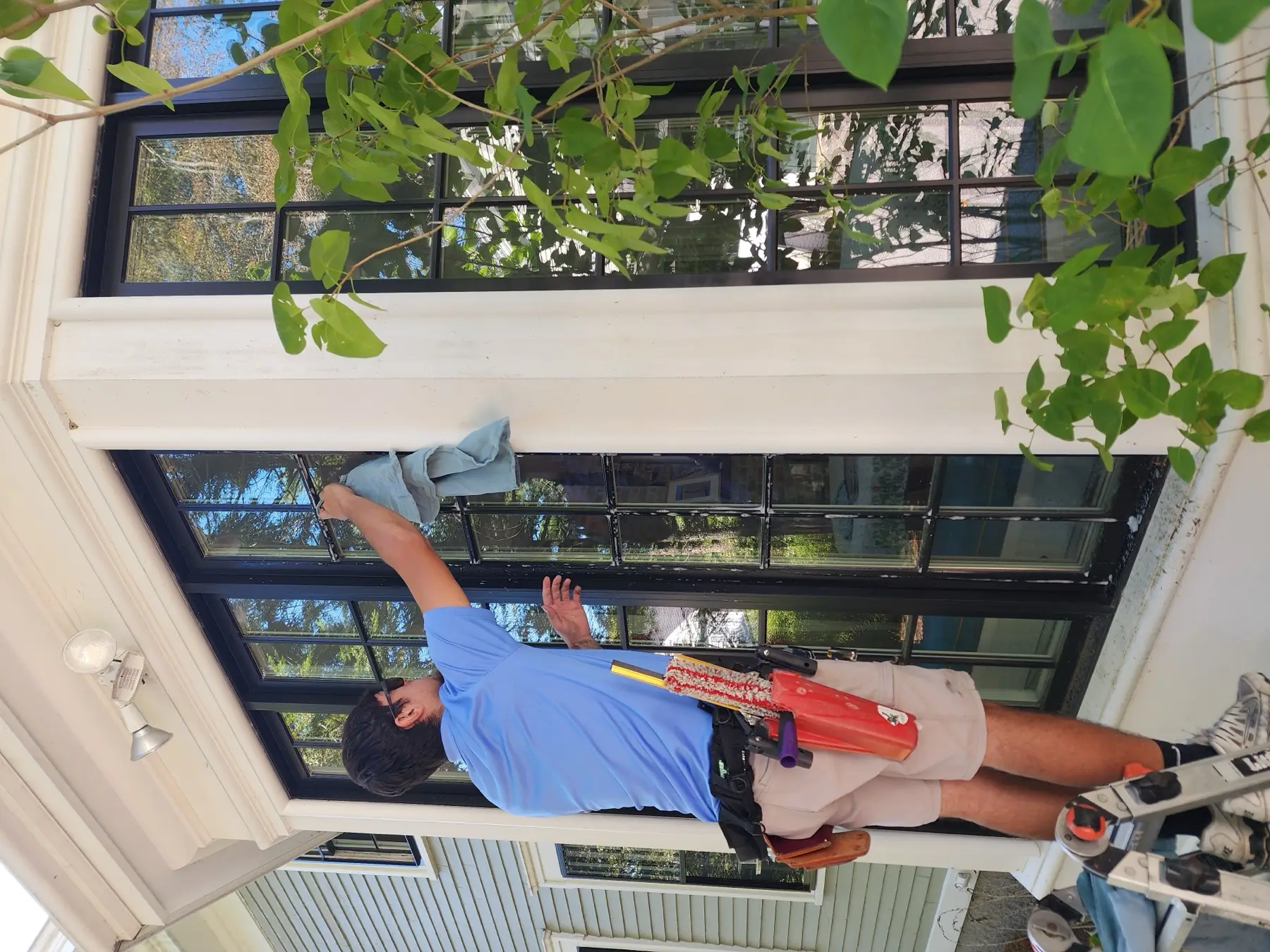 Technician wiping a divided-light window clean